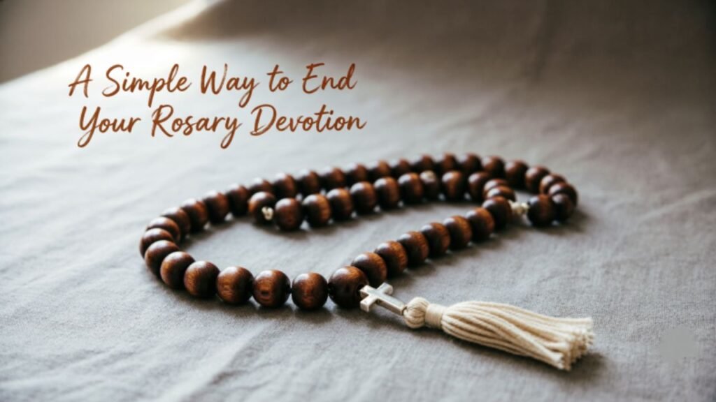 Wooden rosary beads arranged on grey fabric with tassel, illustrating a simple way to end your rosary devotion.
